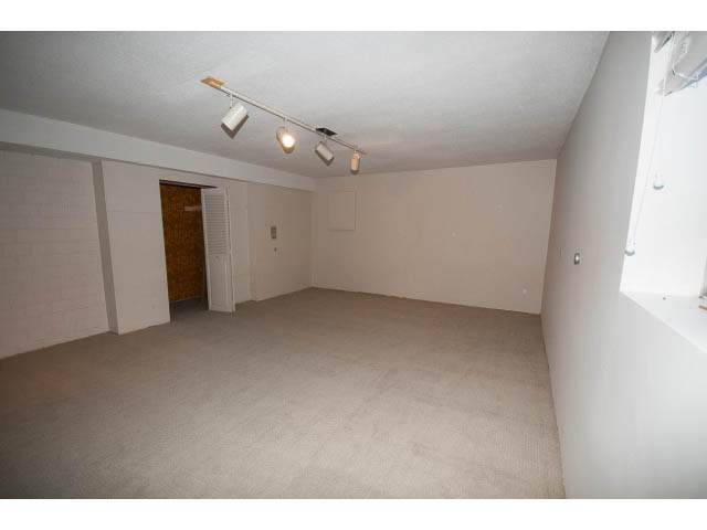Spacious living room with carpeted floors and track lighting. - 610 Newdale Rd., West Vancouver