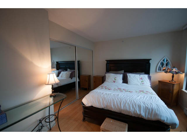 Furnished 1-bedroom condo with hardwood floors and a cozy bed setup. - 404 - 909 Mainland, Vancouver Downtown