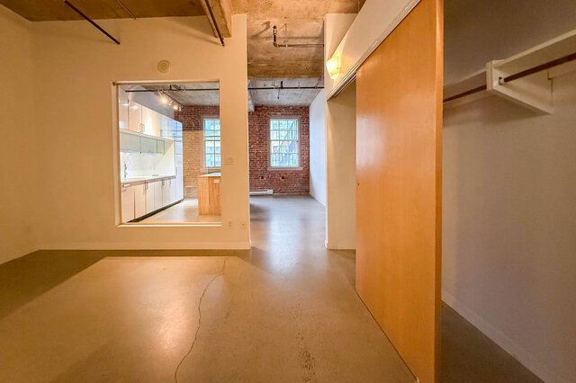 Spacious loft with exposed brick wall, polished concrete floors, and modern kitchen counter. - 308 - 546 Beatty Street, Vancouver Downtown