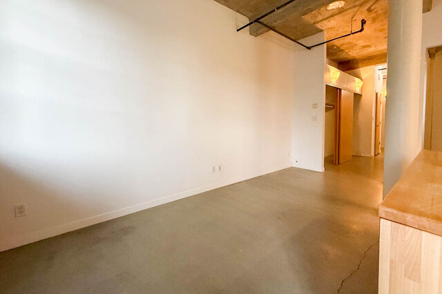 Spacious loft with concrete floors and exposed beams, perfect for a cozy living space. - 308 - 546 Beatty Street, Vancouver Downtown