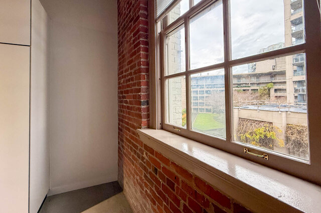 Spacious loft with exposed brick wall and large window offering city views. - 308 - 546 Beatty Street, Vancouver Downtown