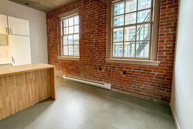 Loft kitchen with brick walls, wooden countertops, and a city view. - 308 - 546 Beatty Street, Vancouver Downtown