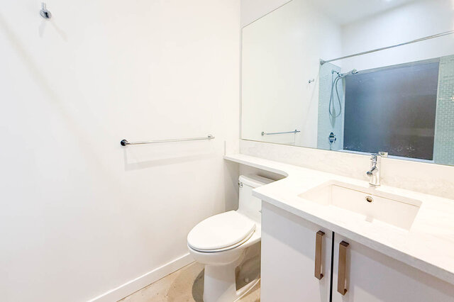 Modern bathroom with white countertops and a large mirror. - 308 - 546 Beatty Street, Vancouver Downtown