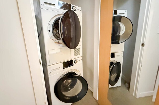 Bright laundry room with stacked washer and dryer, modern design. - 308 - 546 Beatty Street, Vancouver Downtown