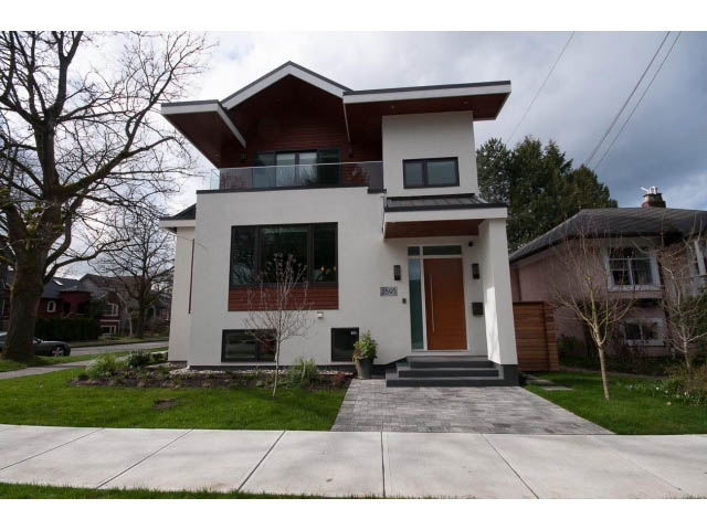 Modern 3-bedroom house with sleek white exterior and wooden accents, large windows, and a spacious front yard.