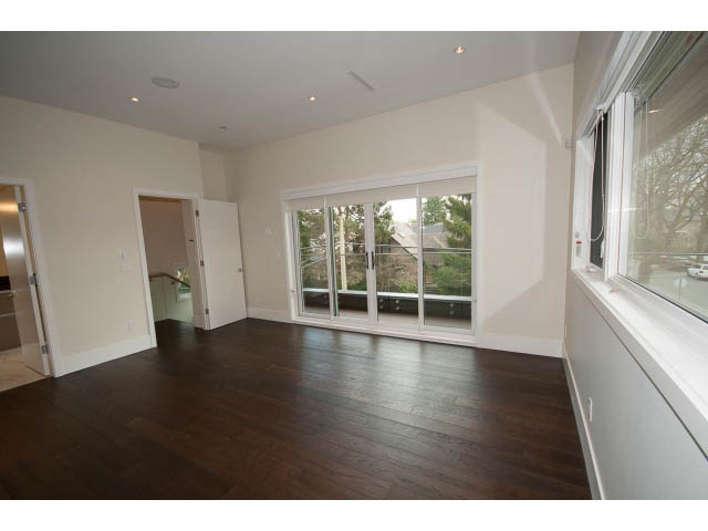 Spacious living room with hardwood floors and large windows offering a city view. - 2895 Balaclava St., Vancouver West Side