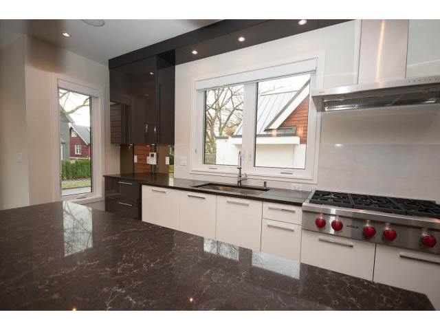 Bright kitchen with marble countertops and modern appliances, featuring a view of the street outside. - 2895 Balaclava St., Vancouver West Side
