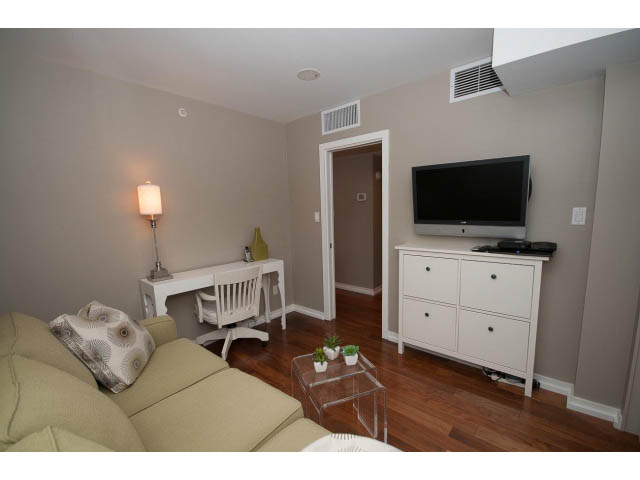 Living room with hardwood floors, white furniture, and a mounted TV. - 901 - 1690 West 8th Ave, Vancouver West Side