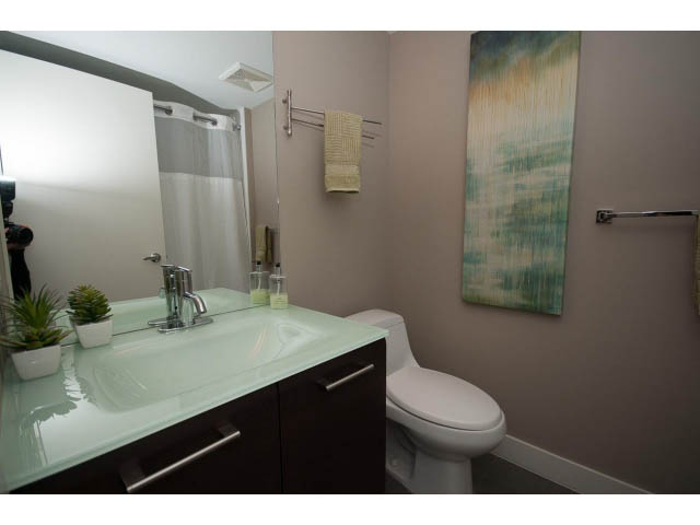 Furnished bathroom with modern sink, glass countertop, and abstract wall art. - 901 - 1690 West 8th Ave, Vancouver West Side