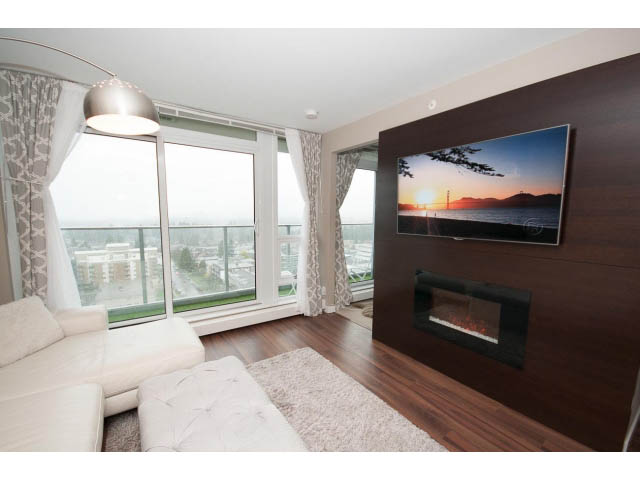 Bright living room with hardwood floors, city view, and modern furnishings. - 1602 - 135 East 17th Street, North Vancouver