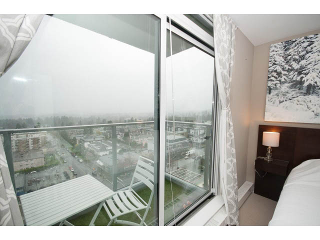 Bright bedroom with city view, modern furnishings, and cozy ambiance. - 1602 - 135 East 17th Street, North Vancouver
