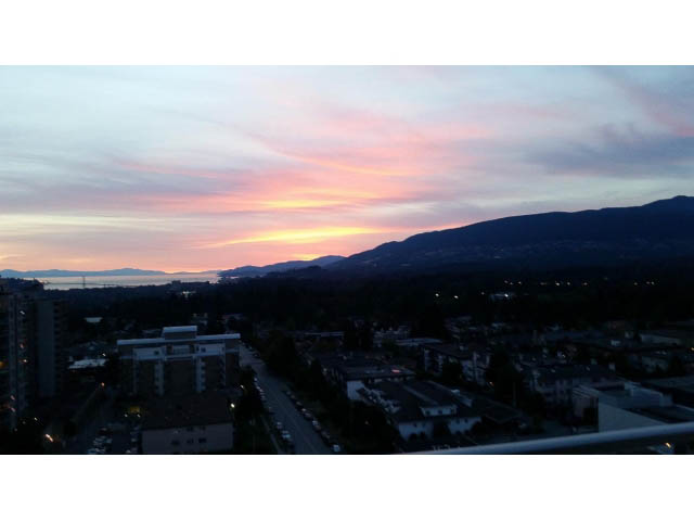 Bright living room with stunning city view and vibrant sunset. - 1602 - 135 East 17th Street, North Vancouver