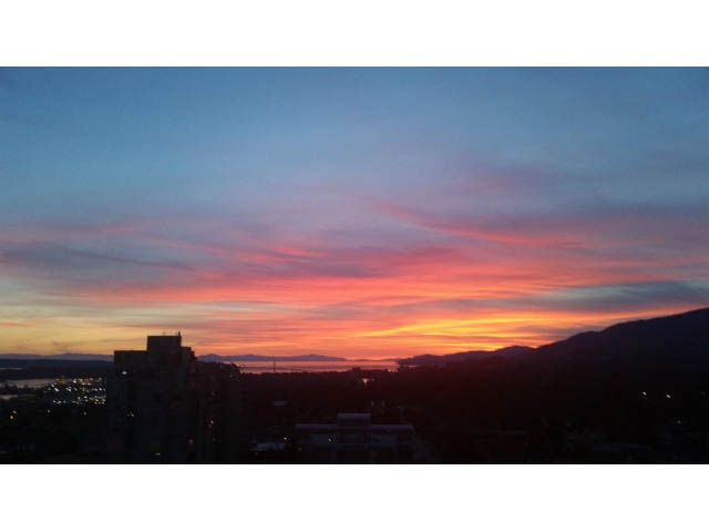 Bright living room with stunning city view at sunset. - 1602 - 135 East 17th Street, North Vancouver