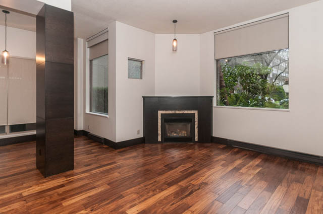 Spacious living room with hardwood floors and a cozy fireplace. - 102 - 1970 Haro St, Vancouver Downtown
