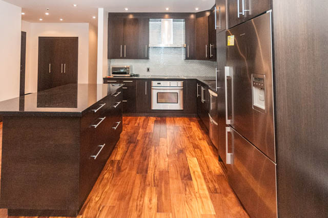 Bright kitchen with dark wood cabinets, granite countertops, and stainless steel appliances. - 102 - 1970 Haro St, Vancouver Downtown