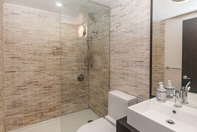 Modern bathroom with stone tiles and a walk-in shower. - 102 - 1970 Haro St, Vancouver Downtown