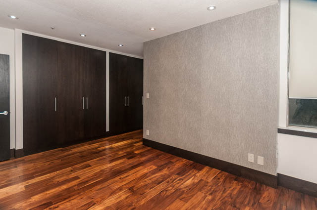 Furnished living room with hardwood floors and dark wood cabinets. - 102 - 1970 Haro St, Vancouver Downtown