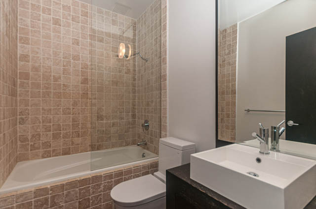 Bright bathroom with modern sink, large mirror, and tiled walls. - 102 - 1970 Haro St, Vancouver Downtown