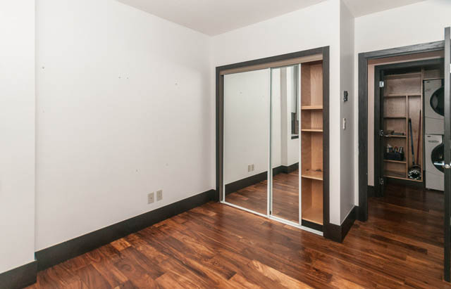 Bright living room with hardwood floors and sliding glass doors leading to a balcony. - 102 - 1970 Haro St, Vancouver Downtown