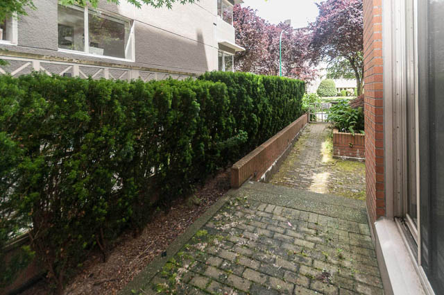 Furnished patio with brick steps and lush green hedge. - 102 - 1970 Haro St, Vancouver Downtown
