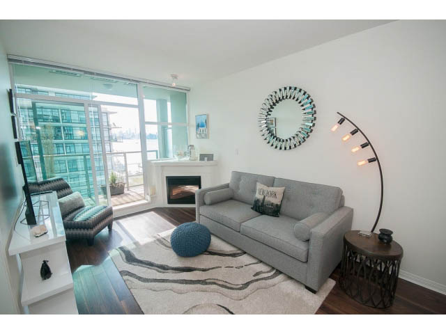 Bright living room with city view, hardwood floors, and modern decor. - 906 - 168 Esplanade, North Vancouver