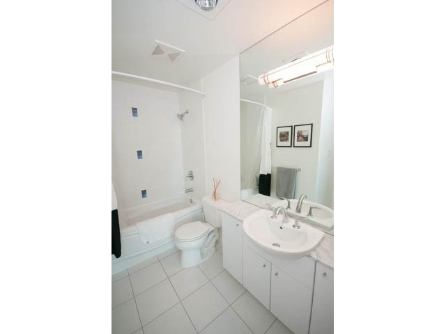 Bright bathroom with white tile, modern sink, and shower. - 906 - 168 Esplanade, North Vancouver