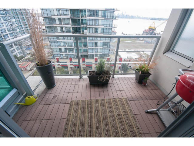Furnished balcony with city view, wooden flooring, and potted plants. - 906 - 168 Esplanade, North Vancouver