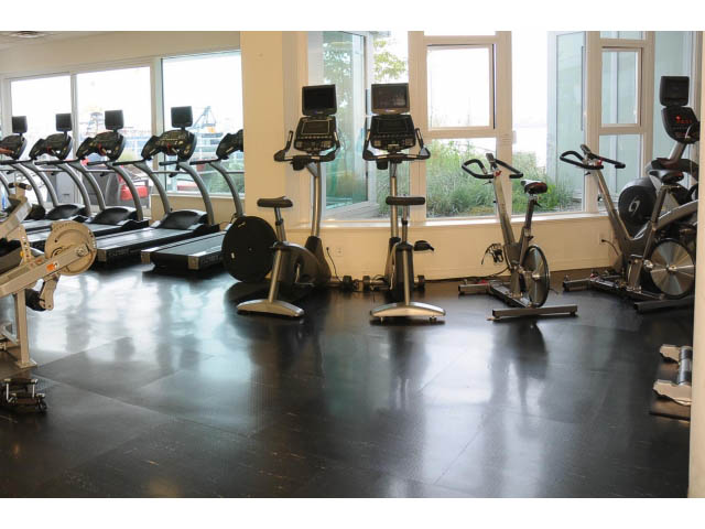 Bright gym with cardio equipment and large windows. - 906 - 168 Esplanade, North Vancouver