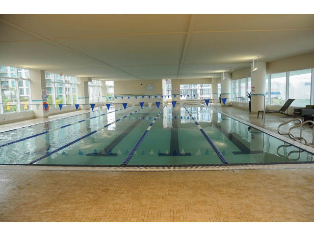 Spacious, well-lit indoor pool with blue lane dividers and tiled flooring. - 906 - 168 Esplanade, North Vancouver