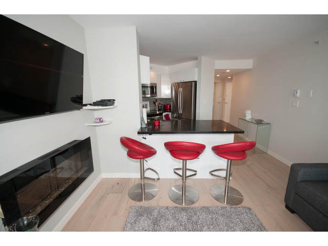 Bright living room with modern furniture, hardwood floors, and a view of the kitchen. - 1502 - 907 Beach Ave, Vancouver Downtown