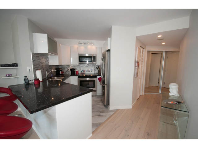 Bright kitchen with black granite countertops and hardwood floors, modern appliances. - 1502 - 907 Beach Ave, Vancouver Downtown