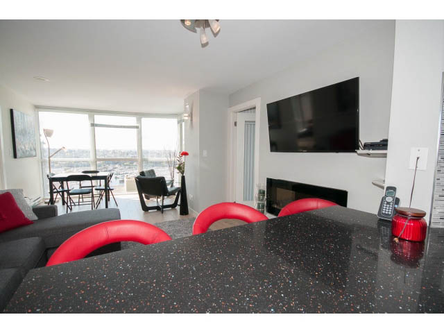 Spacious living room with black speckled countertops, city view, and modern decor. - 1502 - 907 Beach Ave, Vancouver Downtown