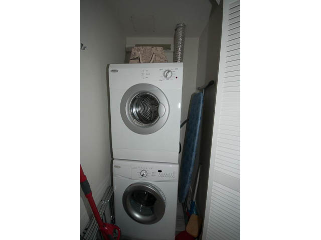 Laundry room with stacked washer and dryer, small space, compact design. - 1502 - 907 Beach Ave, Vancouver Downtown