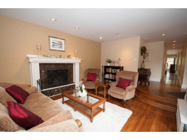 Spacious living room with hardwood floors, fireplace, and plush seating. - Main - 980 Montroyal Blvd, North Vancouver