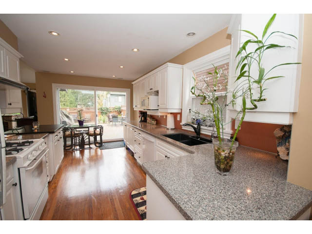 Bright kitchen with granite countertops, hardwood floors, and a city view. - Main - 980 Montroyal Blvd, North Vancouver