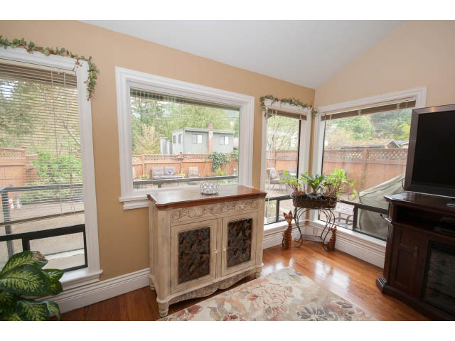 Bright living room with hardwood floors, large windows, and a fireplace. - Main - 980 Montroyal Blvd, North Vancouver