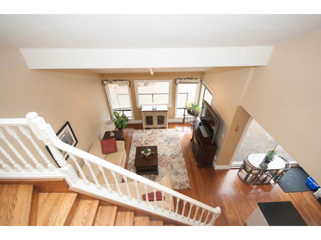 Bright living room with hardwood floors and a cozy corner. - Main - 980 Montroyal Blvd, North Vancouver