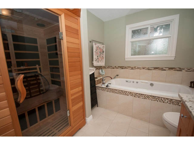 Shared bathroom with tiled walls, granite countertop, and a window. - Main - 980 Montroyal Blvd, North Vancouver