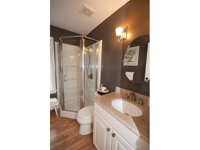 Spacious bathroom with granite countertops, hardwood floors, and a walk-in shower. - Main - 980 Montroyal Blvd, North Vancouver