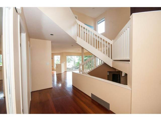 Staircase leading to upper level with white railings and hardwood floors. - 3890 Sharon Drive, West Vancouver