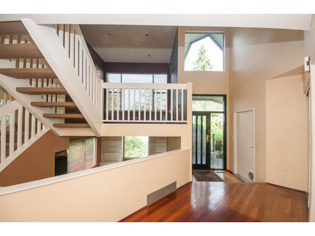 Open-concept living area with hardwood floors and a modern staircase. - 3890 Sharon Drive, West Vancouver