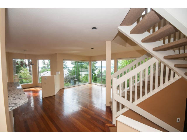 Bright living room with hardwood floors and modern staircase. - 3890 Sharon Drive, West Vancouver