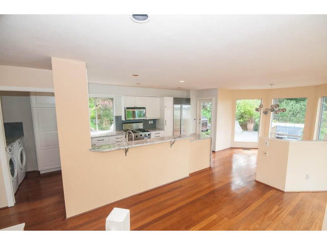 Open-concept living area with hardwood floors and a view of greenery outside. - 3890 Sharon Drive, West Vancouver