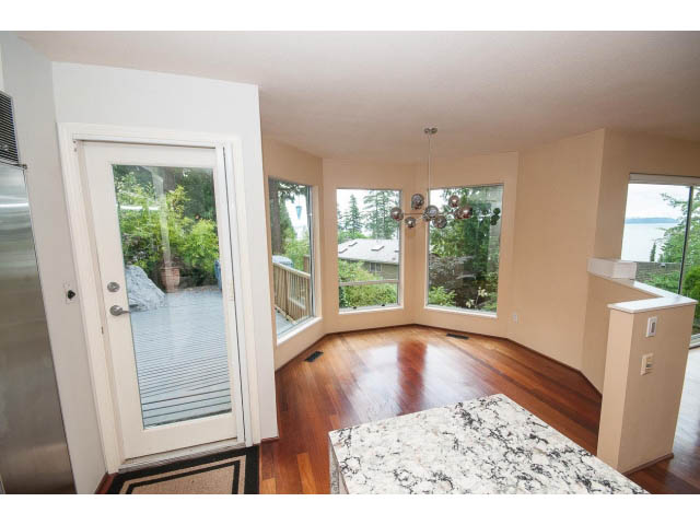 Open-concept living area with hardwood floors, granite countertops, and a view of the outdoors. - 3890 Sharon Drive, West Vancouver