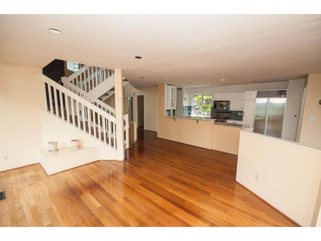 Open-concept living area with hardwood floors and a white staircase leading to the upper level. - 3890 Sharon Drive, West Vancouver