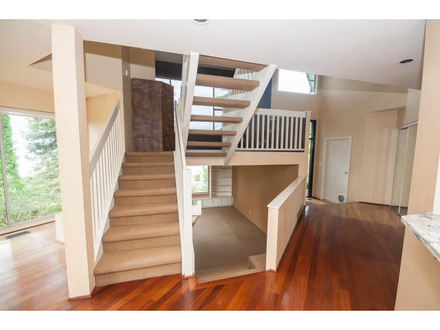 Bright open-concept living space with hardwood floors, modern staircase, and city view. - 3890 Sharon Drive, West Vancouver