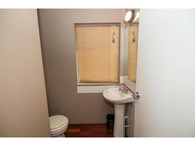 Small bathroom with white sink, toilet, and window with blinds. - 3890 Sharon Drive, West Vancouver