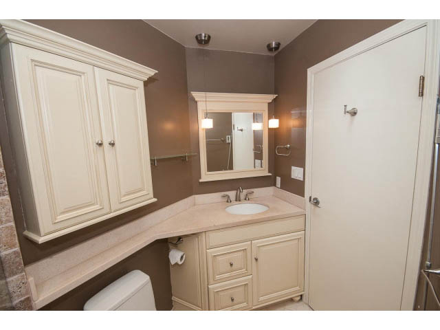 Spacious bathroom with beige cabinets and a large mirror. - 3890 Sharon Drive, West Vancouver