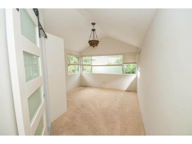 Bright hallway with carpeted floor and large windows, leading to a sunroom. - 3890 Sharon Drive, West Vancouver