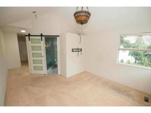Bright living room with beige carpet and sliding glass door leading to another room. - 3890 Sharon Drive, West Vancouver